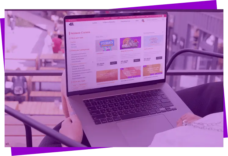 Imagem com filtro roxo de um notebook sobre o colo de uma pessoa; na tela é exibido a página de cursos do site da Descola
